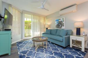 ein Wohnzimmer mit einem blauen Sofa und einem Tisch in der Unterkunft Maui Banyan Q-109 in Wailea