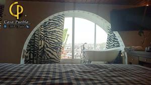 sypialnia z łóżkiem, krzesłem i oknem w obiekcie Hotel Temático Casa Puebla w mieście Puebla