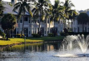 那不勒斯的住宿－GreenLinks Luxury Villa at Lely Resort Golf - 3 Bedrooms，棕榈树建筑前的喷泉