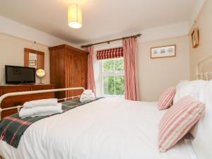 a bedroom with a large white bed and a window at Banneth in Mawgan in Meneage