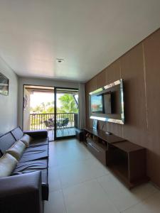 a living room with a couch and a flat screen tv at RESORT MARULHOS PORTO DE GALINHAS FLAT C405 in Porto De Galinhas
