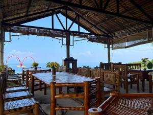 a restaurant with tables and chairs with a view of the ocean at Thornton's Sea View Cafe & Guesthouse in Siquijor