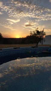 un coucher de soleil au-dessus d'une piscine avec la réflexion du ciel dans l'établissement Quinta da Fé, 