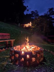 諾凱馬的住宿－Cabañas Wilú，长凳旁边的草地上的火坑
