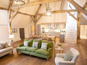 a living room with a green couch and a kitchen at Olivers Barn - Uk42081 in East Garston