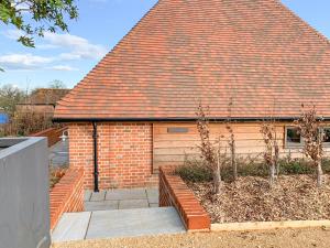 een stenen huis met een rood dak en enkele bomen bij Olivers Barn - Uk42081 in East Garston