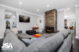 ein Wohnzimmer mit einem Sofa und einem Kamin in der Unterkunft Edelweiss Cottage in Berridale