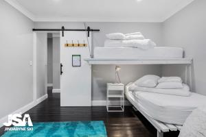 2 Etagenbetten in einem Zimmer mit blauem Teppich in der Unterkunft Edelweiss Cottage in Berridale