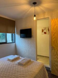 1 dormitorio con 1 cama con 2 toallas en Depto en Barrio Villa Belgrano excelente ubicación en Córdoba