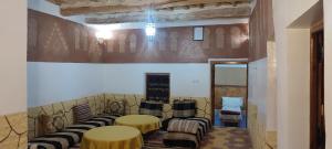 una habitación con 2 mesas y sillas y una pared en Gîte Assafar, en Kalaat MGouna