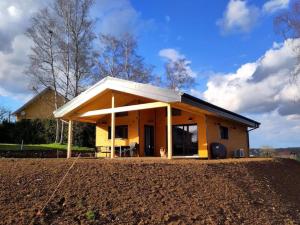 a house with a roof on top of a field at Gîte chalet, Au Doubs Logis in Pierrefontaine-les-Varans