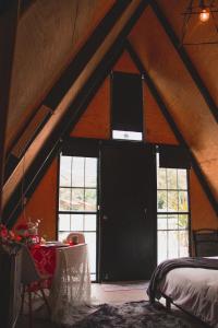 a bedroom with a large door in a attic at Glamping Nool in Río Blanco