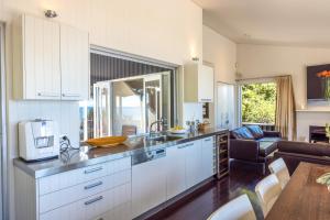 a kitchen with white cabinets and a living room at Black Bach in Onetangi