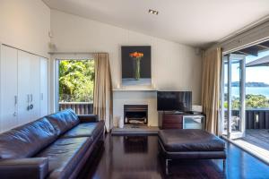 a living room with a leather couch and a fireplace at Black Bach in Onetangi