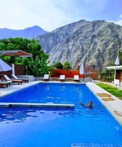 una persona nadando en una gran piscina azul en HOTEL MAR Y LAGO, en Lunahuaná