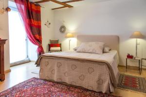 a bedroom with a bed and a large window at La Maison des Tanneurs in Ribeauvillé