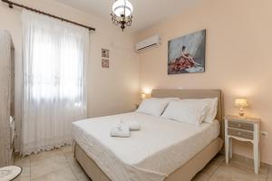 a bedroom with a large bed and a window at Villa of Roses in Naxos - Private villa with pool in Naxos Chora