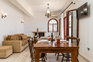 a dining room with a table and a couch at Villa of Roses in Naxos - Private villa with pool in Naxos Chora
