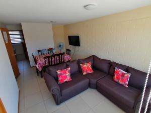 ein Wohnzimmer mit einem braunen Sofa und rosa Kissen in der Unterkunft Casa en Padre Hurtado IV in Talagante