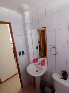 W łazience znajduje się umywalka, toaleta i lustro. w obiekcie Casa en Padre Hurtado IV w mieście Talagante