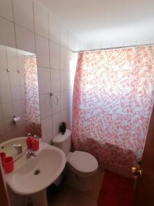 ein Badezimmer mit einem weißen WC und einem Waschbecken in der Unterkunft Casa en Padre Hurtado IV in Talagante