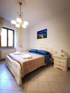 a bedroom with a large white bed and a chandelier at La Casa di Lice in Moneglia