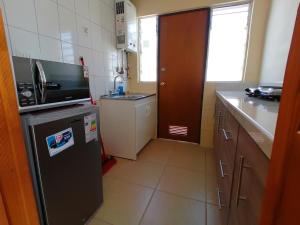 a small kitchen with a refrigerator and a counter at Agradable casa en Padre Hurtado VI in Talagante