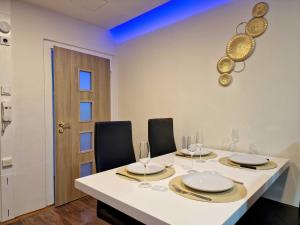 a dining room with a white table and chairs at Wellness Gold apartment with Private SAUNA & JACUZZI in Prague