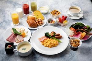a table with plates of breakfast foods and drinks at Hotel Kanazawa in Kanazawa