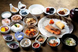 uma mesa coberta com tigelas e pratos de comida em Hotel Kanazawa em Kanazawa
