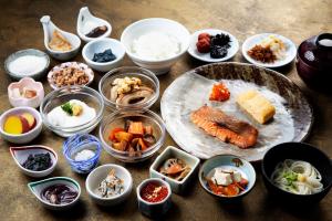 une table recouverte de bols et de assiettes de nourriture dans l'établissement Hotel Kanazawa, à Kanazawa