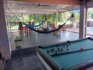 a room with a pool table and a hammock at Natalias Beach House in Matapalo