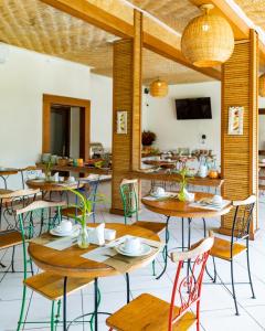 un restaurante con mesas, sillas y TV en Riviera Búzios Hotel en Búzios
