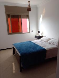 - une chambre avec un lit et une couverture bleue dans l'établissement Hammadi's house, à Oualidia