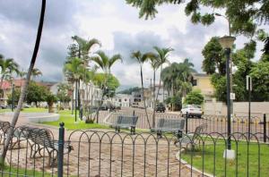 a fence with benches in a park with palm trees at Mega Suite in Privileged area of San Marino in Guayaquil