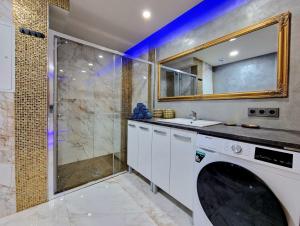 ein Bad mit einer Waschmaschine und einer Dusche in der Unterkunft Wellness Gold apartment with Private SAUNA & JACUZZI in Prag