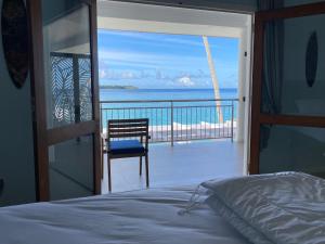 a bedroom with a bed and a view of the ocean at Nasara Resort Mentawai in Tua Pejat