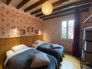 a bedroom with two beds and a window at Semi-detached house Etretat - NMD01100d-L in Étretat