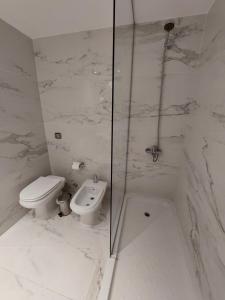 a white bathroom with a toilet and a shower at Avellaneda Aparts & Suites in Buenos Aires