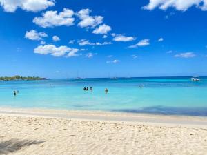 een groep mensen in het water op een strand bij Bridget Place in Bayahibe