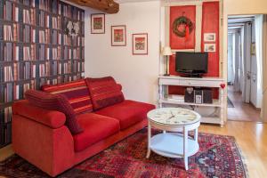 a living room with a red couch and a tv at La Maison des Tanneurs in Ribeauvillé