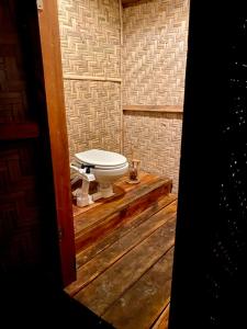 a bathroom with a toilet on a wooden platform at Camp Tarimbang in Tandulujangga