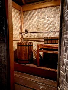 an inside view of a wooden cabin with a bucket at Camp Tarimbang in Tandulujangga