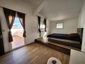 a bedroom with a bed and a large window at beaux duplex in Deli Ibrahim