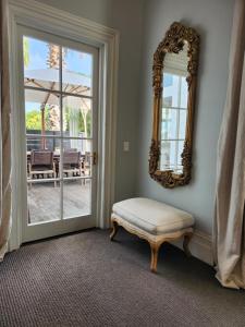 a mirror and a ottoman in front of a door at Cedar House in Gisborne