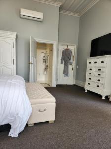 a bedroom with a bed and a dresser and a tv at Cedar House in Gisborne