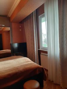 a hotel room with a bed and a window at Apartment ЖУЖУНА in Batumi