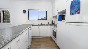 邦加里Modern Unit With Penthouse Views的厨房配有白色橱柜和窗户。