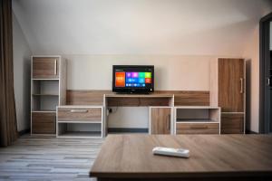 a room with a tv on a desk with a table at Green Town Apartment in Chortkiv