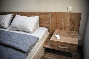 a bedroom with a bed and a nightstand with a remote control at Green Town Apartment in Chortkiv